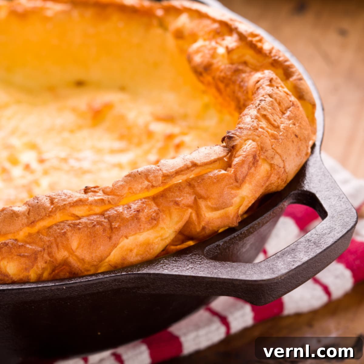 Αφράτη, χρυσαφένια Dutch baby τηγανίτα μόλις βγήκε από τον φούρνο σε ένα μαντεμένιο τηγάνι.