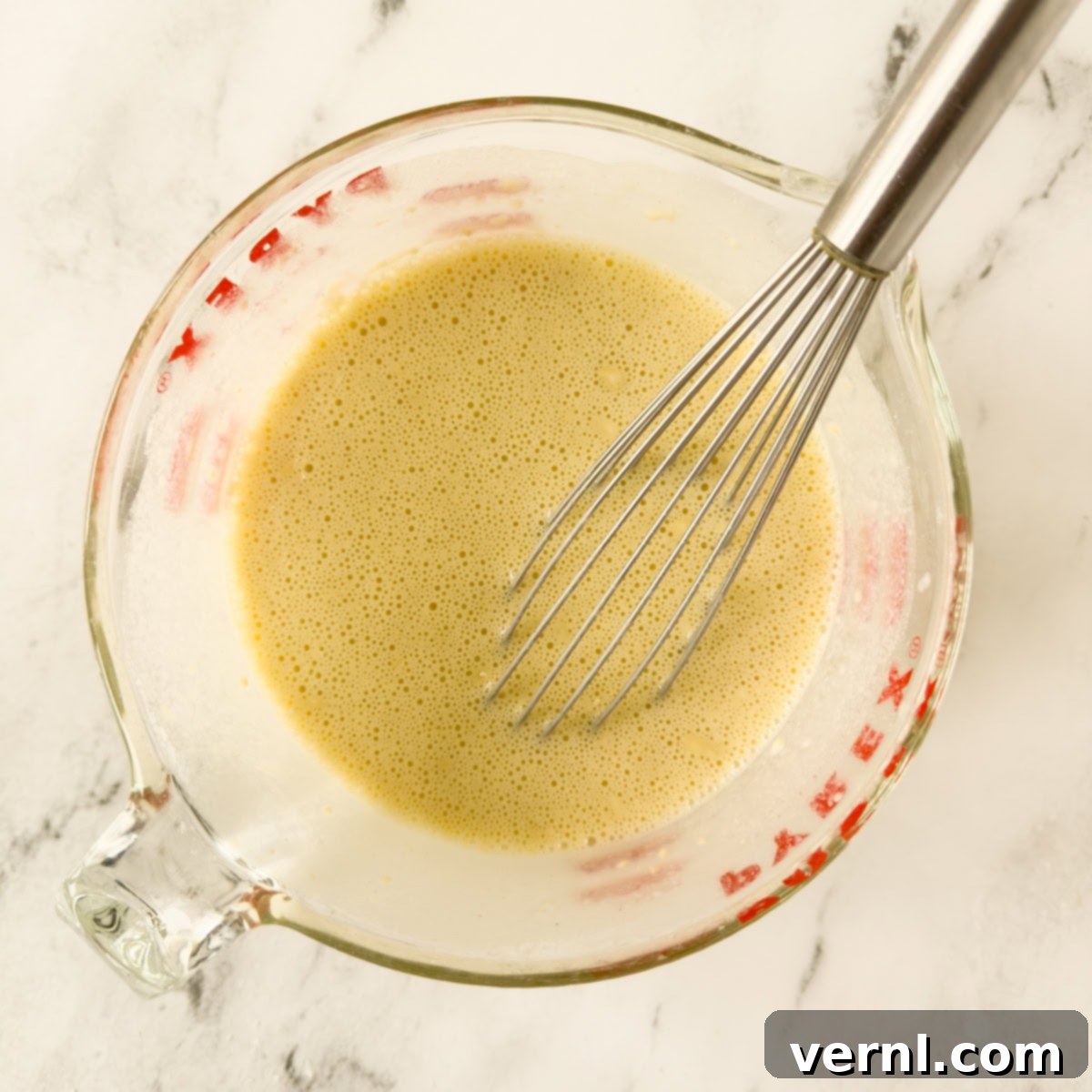 Ζύμη για μια dutch baby τηγανίτα με αυγοδάρτη σε ένα γυάλινο δοχείο μέτρησης.