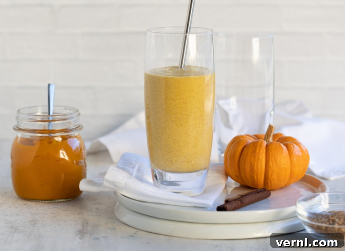 Σμούθι Κολοκύθας 8 Κολοκυθόπιτα smoothie στον πάγκο με μια μίνι κολοκύθα και βάζο πουρέ κολοκύθας.