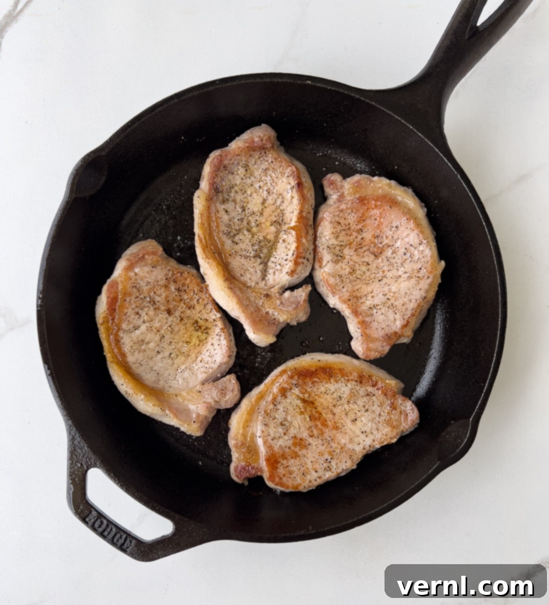 Χοιρινές Μπριζόλες Ξινής Κρέμας 5 Browned pork chops in cast iron.