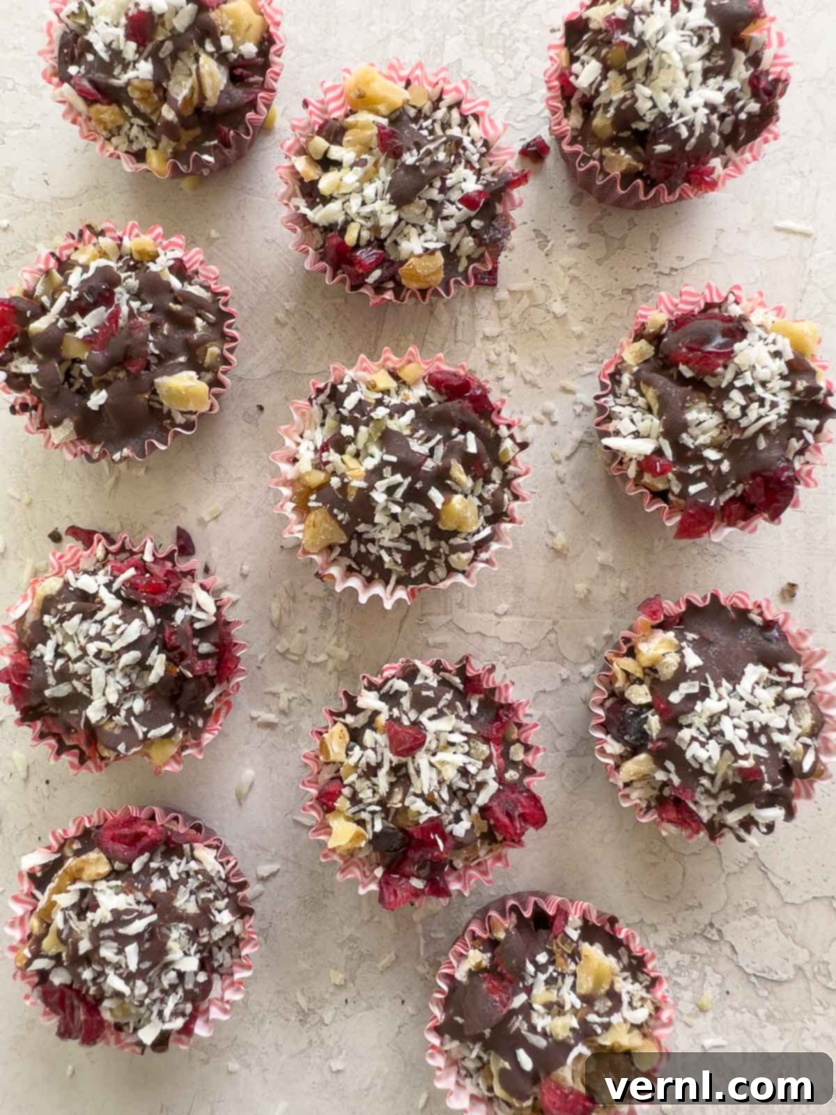 Σοκολατένια Σπάσματα 6 Bites μαύρης σοκολάτας bark με κράνμπερι, καρύδια και καρύδα σε πάγκο κουζίνας.