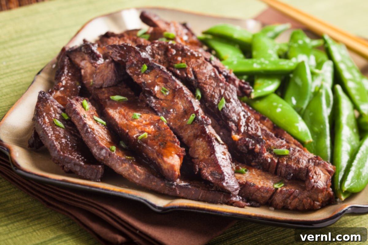 Μοσχάρι Σοτέ με Πιπερόριζα 2 Γλασσαριστό stir-fry με flank steak και τζίντζερ σε πιάτο με πράσινα sugar snap peas.