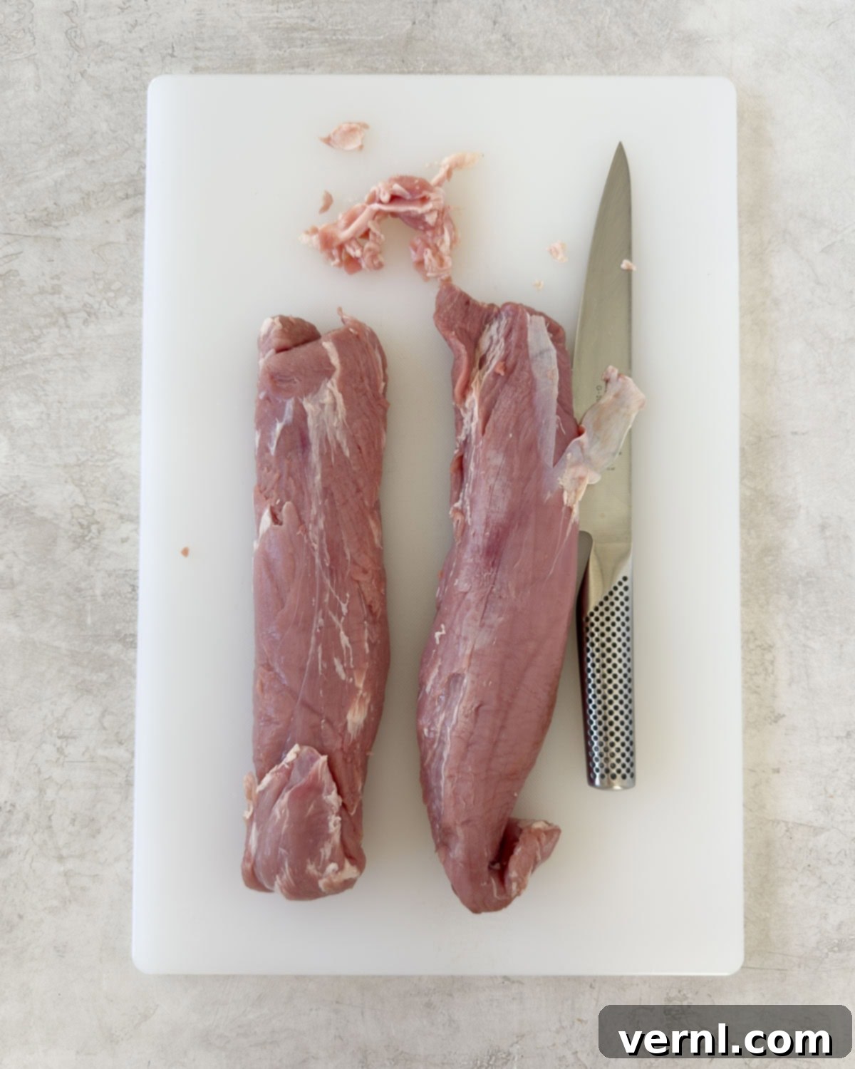 Καπνιστό χοιρινό ψαρονέφρι 4 Trimming two pork tenderloins of silver skin and excess fat on a cutting board.