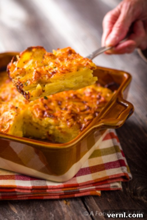 Κομμάτι Πατάτες Gratin Οι τελειωμένες πατάτες, χρυσαφένιες στρώσεις σε κουτάλα σερβιρίσματος.