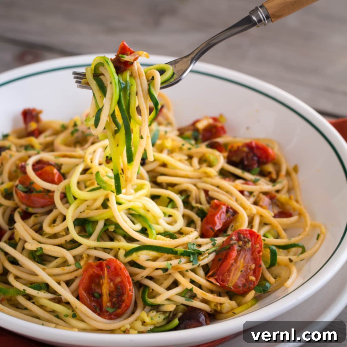 Noodles κολοκυθιού με ψητές ντομάτες σε ένα μπολ.