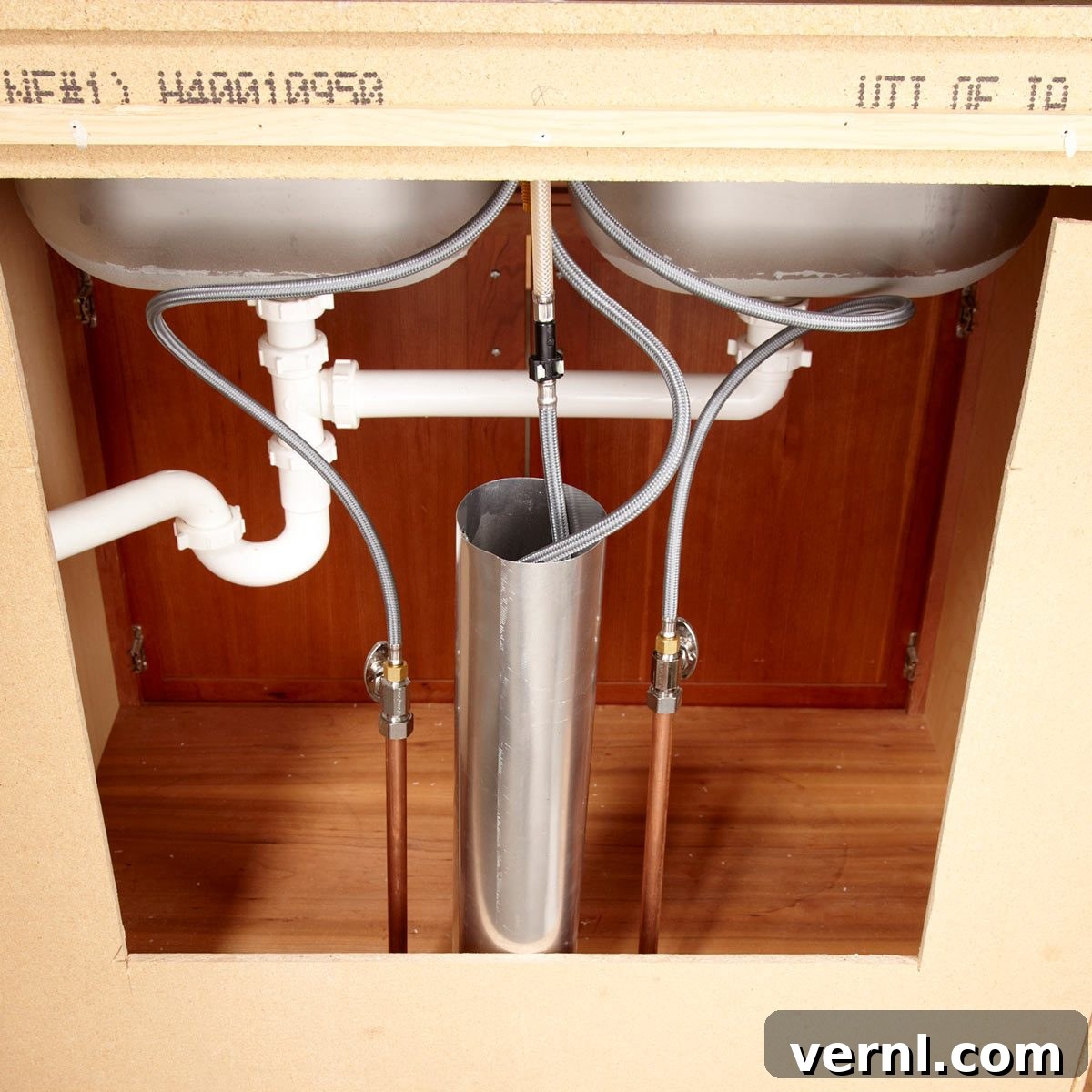 Kitchen sink cabinet interior with a pullout faucet hose contained within a heating duct tube