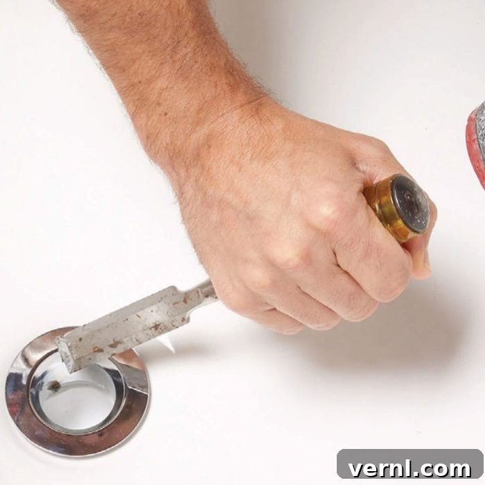 Unlock That Bathtub Drain 5 Loosening A Bathtub Drain Using A Chisel And Hammer With Hands