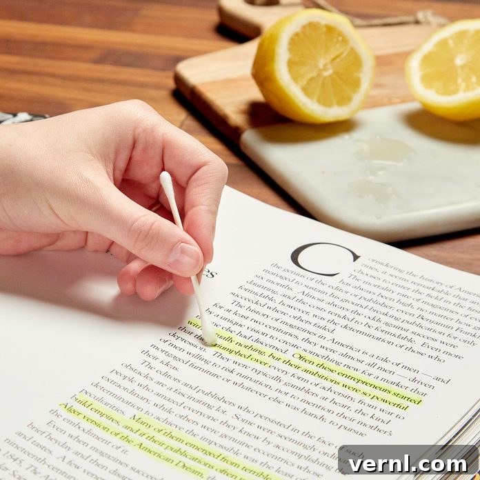 Close-up of lemon juice actively fading a highlighter mark on a book page