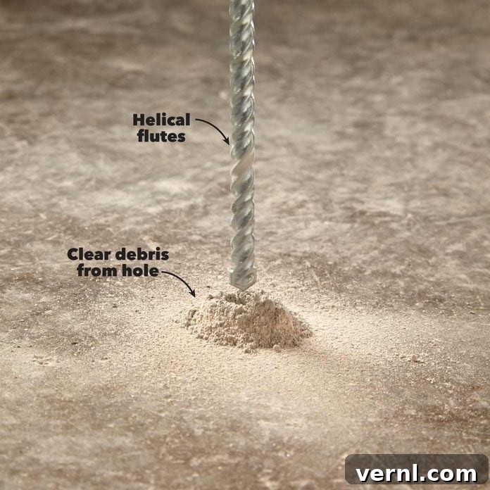 Rotary vs. Hammer Drills: Picking the Right Tool 10 Worker demonstrating how to clear debris from a drilled hole in concrete for better efficiency