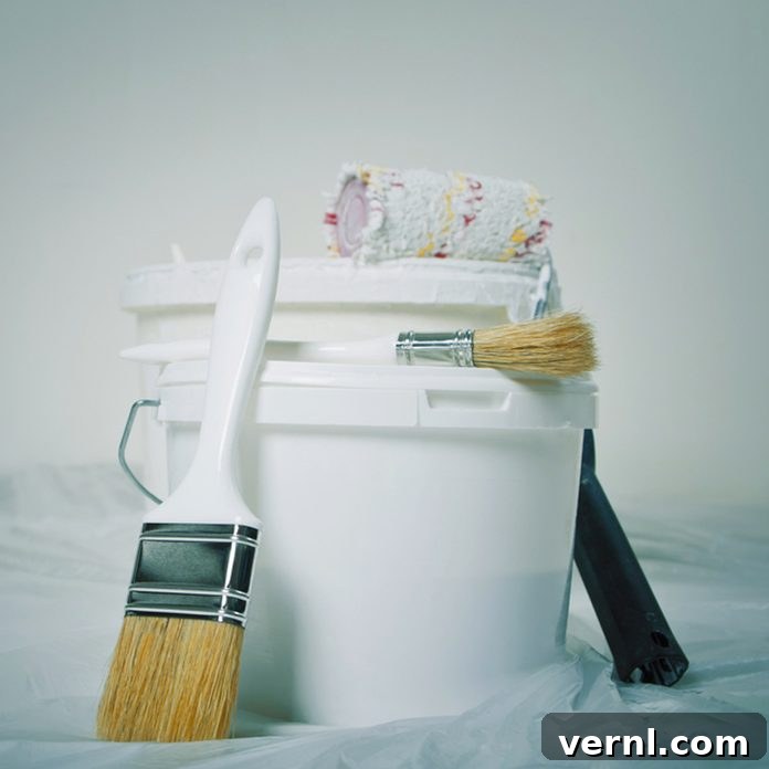 Elevate Your Home: The Ultimate Guide to Choosing Paint Colors Now 4 Close-up of various painting supplies including brushes, rollers, paint cans, and tape laid out for a project.
