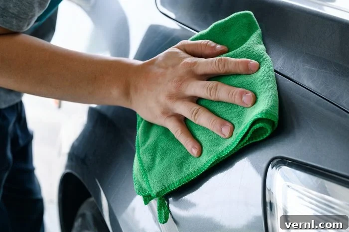 Scratch Free Shine Your Ultimate Guide to Car Paint Correction 5 Man cleaning car with green microfiber cloth on hood