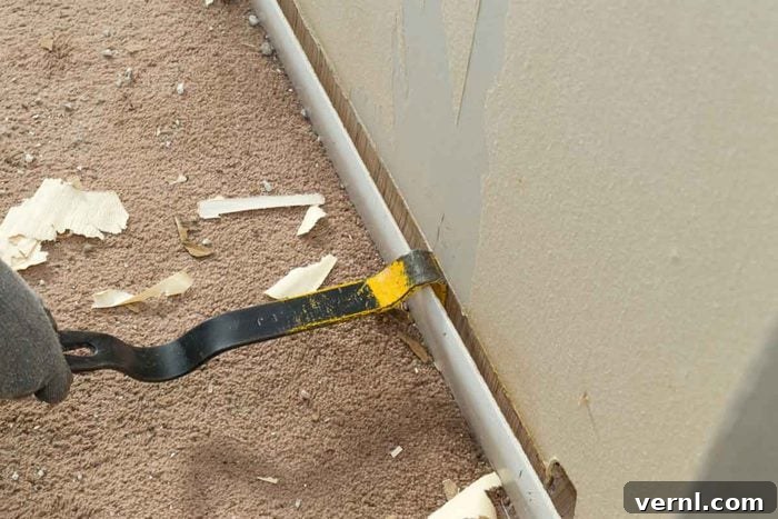 Removed baseboards revealing potential damage or pests behind them