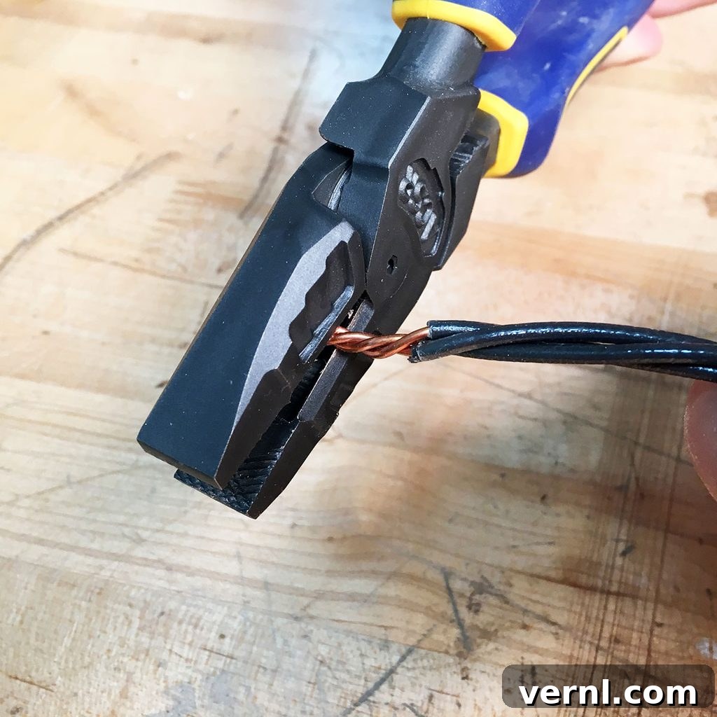 Lineman's pliers shown in action, clipping twisted copper wires to a precise length on a wooden workbench, indicating the final stage of wire preparation.