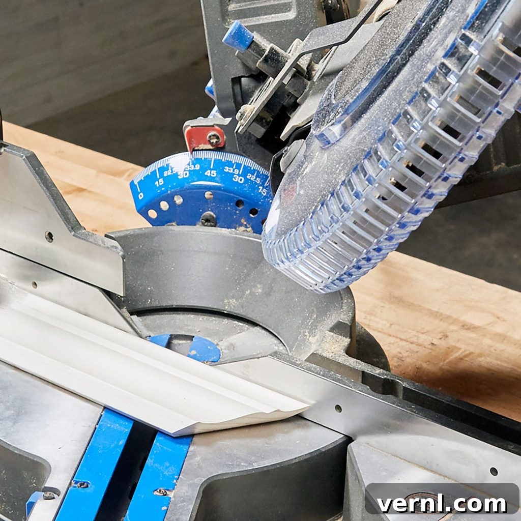 Cutting Crown Molding Flat on a Miter Saw for Precision A piece of crown molding laid flat on a miter saw, ready for a precise cut. This setup enhances safety and accuracy for DIY trim installation.