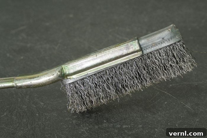 Old metal wire brush with steel handle on grey table