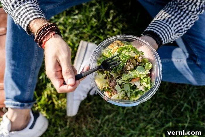 Beyond the Bin: 11 Clever Takeout Container Transformations 2 Man sitting on a meadow eating mixed salad, partial view