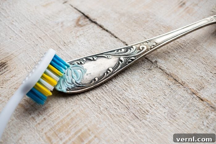Unlock Silver's Brilliant Shine 2 Cleaning tarnished silverware with a toothbrush and non-abrasive toothpaste.