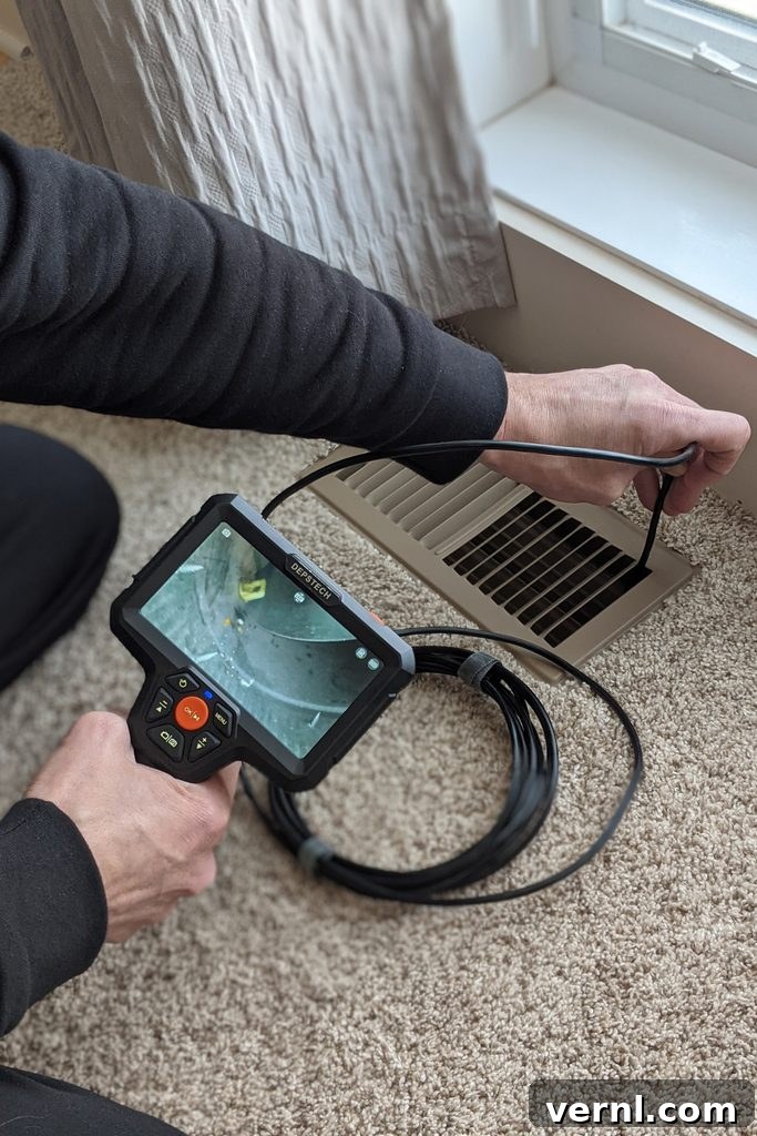 Why Every DIYer Needs This Surprisingly Useful Endoscope 4 Inspecting an HVAC register for proper damper alignment with the Depstech DS500 endoscope
