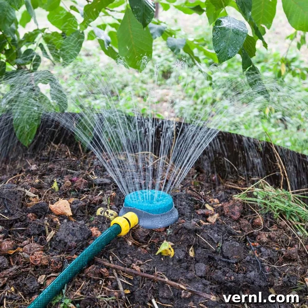 Kickstarting Your Compost Pile 2 Sprinkler watering plants, grass, and a compost pile