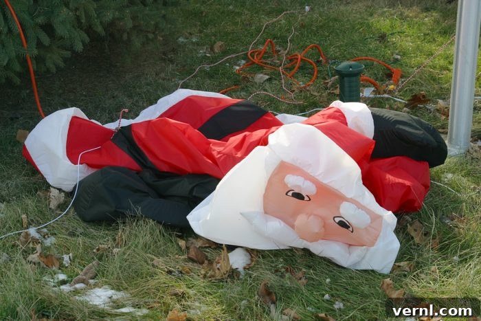 The Unwritten Rules of Christmas Light Removal 2 deflated Santa blow up lawn decoration