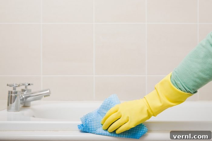 The Ultimate Guide To A Sparkling Bathroom 2 Person cleaning bath with a scrub brush and cleanser