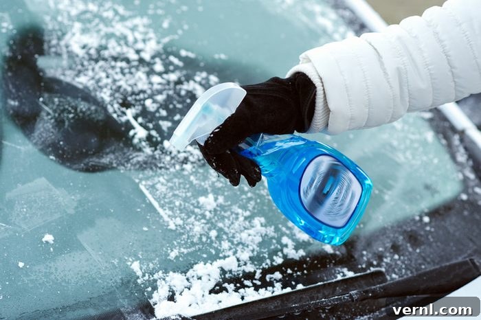 Simple Windshield Defrosting Hack 2 Person scraping ice from car windshield with a defroster spray bottle nearby.
