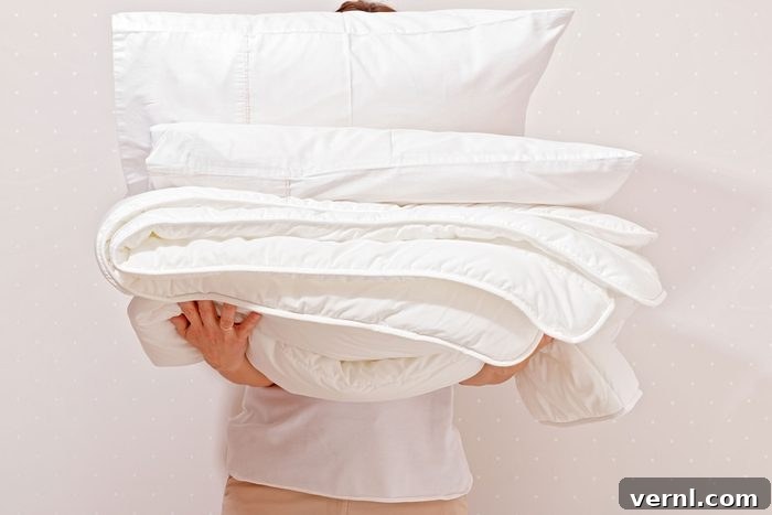 Refresh Your Down Comforter: Washing Made Simple 2 Woman Holding A Pile Of Bedding For Sleeping