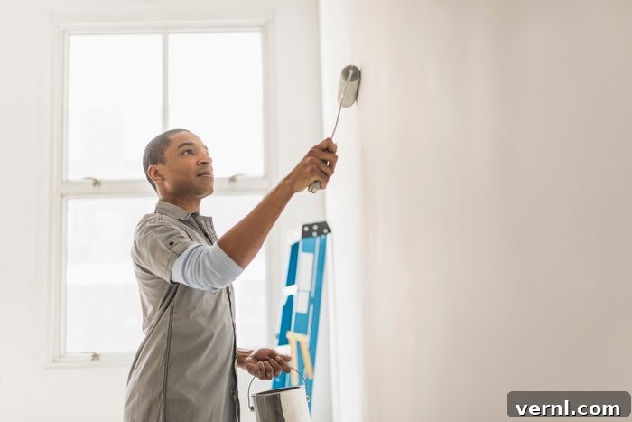 Black man painting wall of home