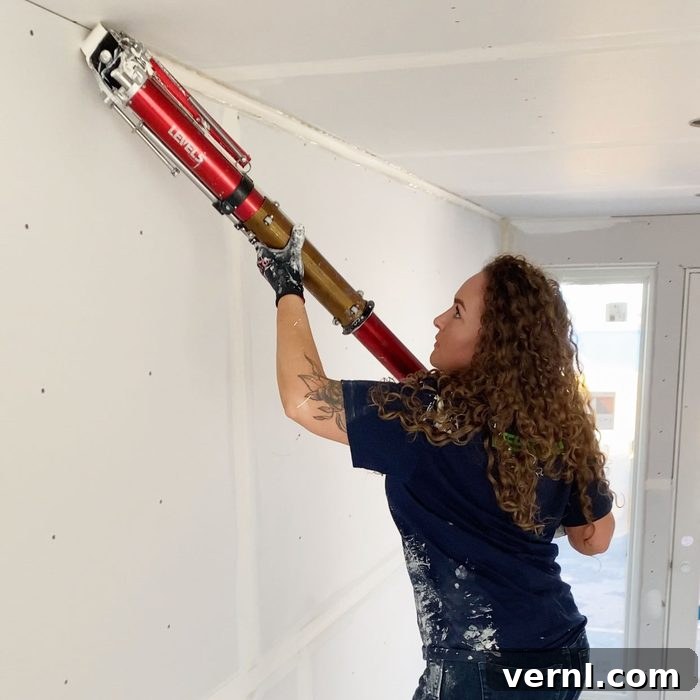Behind the Boards with Drywall Shorty 3 Lydia Crowder demonstrating basic drywall techniques, emphasizing careful application.