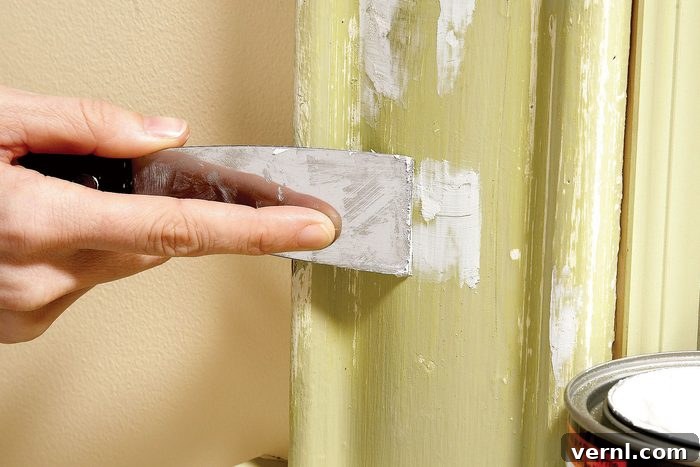 11 Professional Secrets for Perfect Trim Painting 3 A person applying wood filler to fill holes in a pipe
