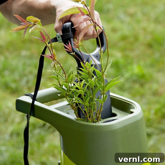 Simplify Garden Cleanup with the Sun Joe Chipper Shredder 2 Sun Joe Chipper in action, shredding branches