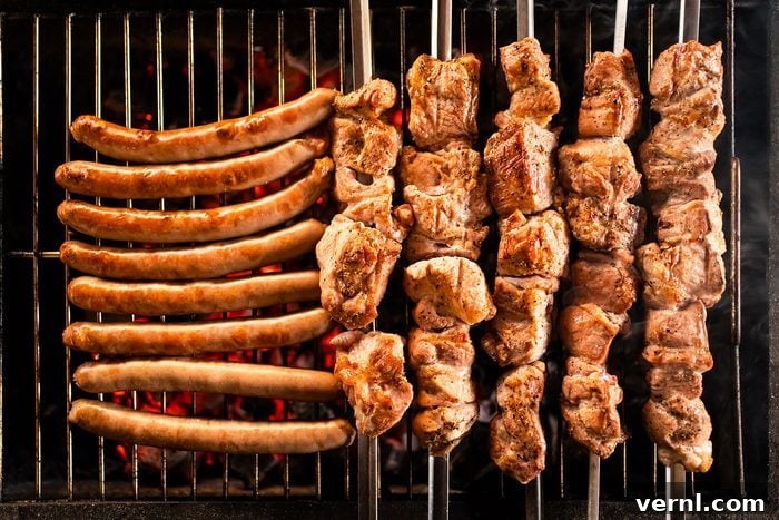 Meat On Skewers And Sausages Are Cooking On The Grill