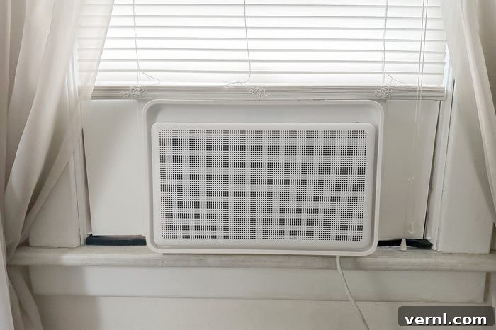 Windmill AC Window Unit: The Hype Is Deserved 2 The sleek, modern Windmill Air Conditioner installed in a window, showcasing its minimalist design and compact form factor. A contemporary solution for efficient home cooling.