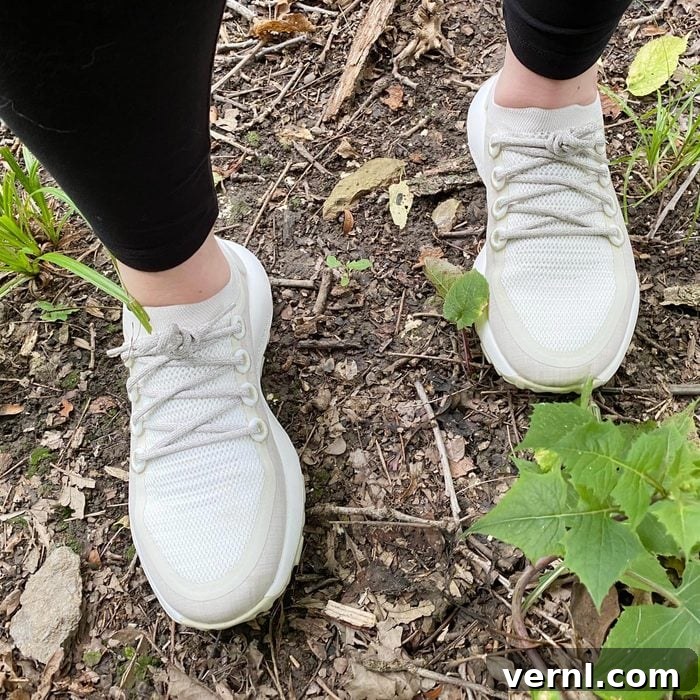 Allbirds Trail Runner in action, walking through a lush forest path, demonstrating its natural habitat.