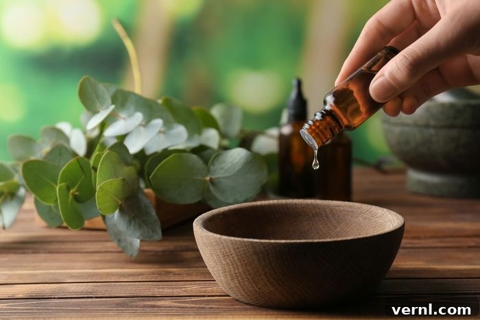 Homemade Clove Oil Bug Repellent for Natural Pest Management 2 Woman Pouring Eucalyptus Essential Oil Into Bowl On Wooden Table
