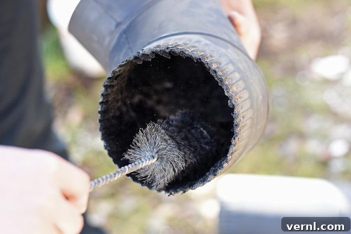 Creosote Unveiling Its Harmful Truths 2 Man Cleaning and Sweeping Chimney Pipe Outside