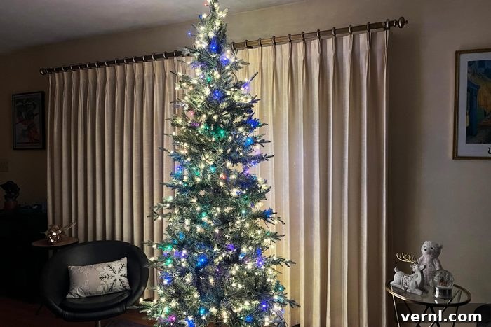 A beautifully decorated Christmas tree with vibrant multicolored Twinkly lights in a cozy living room setting.