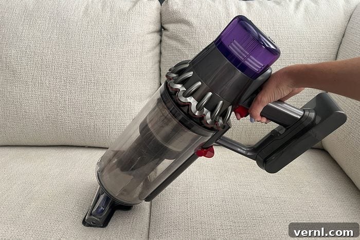 Dyson Outsize Plus using the Hair Screw Tool to clean a couch