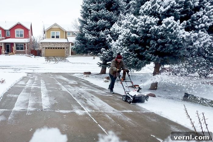This Cordless Worx Blower Turns Snow Removal Into a Joy 4 A man driveway blowing out snow from the driveway