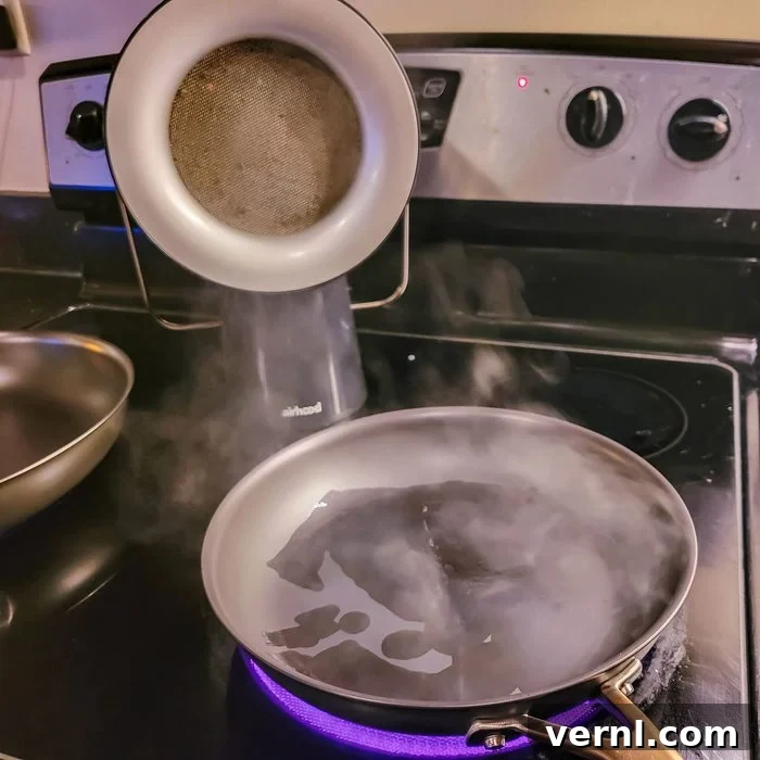 AirHood Portable Kitchen Cleaner Truly Transforms Air Quality 4 AirHood testing with frying pan, focusing on steam and smoke being drawn into the unit