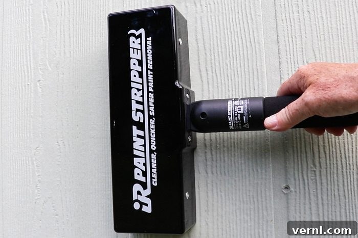 A person holding spengar to remove the paint