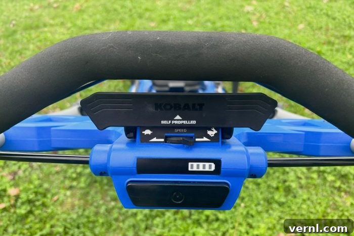 Close up of the back side of Kolbalt Electric Mower, highlighting its robust rear wheels and cutting deck.