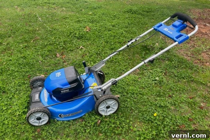 Electric mower actively cutting grass on the front yard, demonstrating its efficiency and ease of use.
