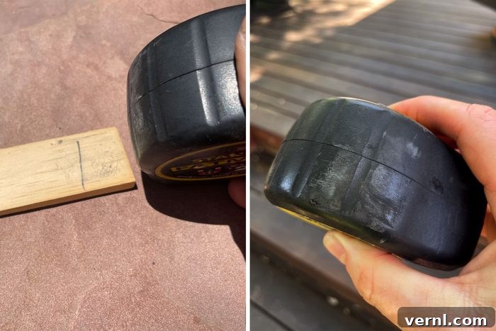 The Life-Changing Tape Measure Trick You Never Knew You Needed 2 A hand demonstrating the tape measure eraser hack, rubbing the rubber grip of a tape measure over a pencil mark on a piece of wood to erase it.