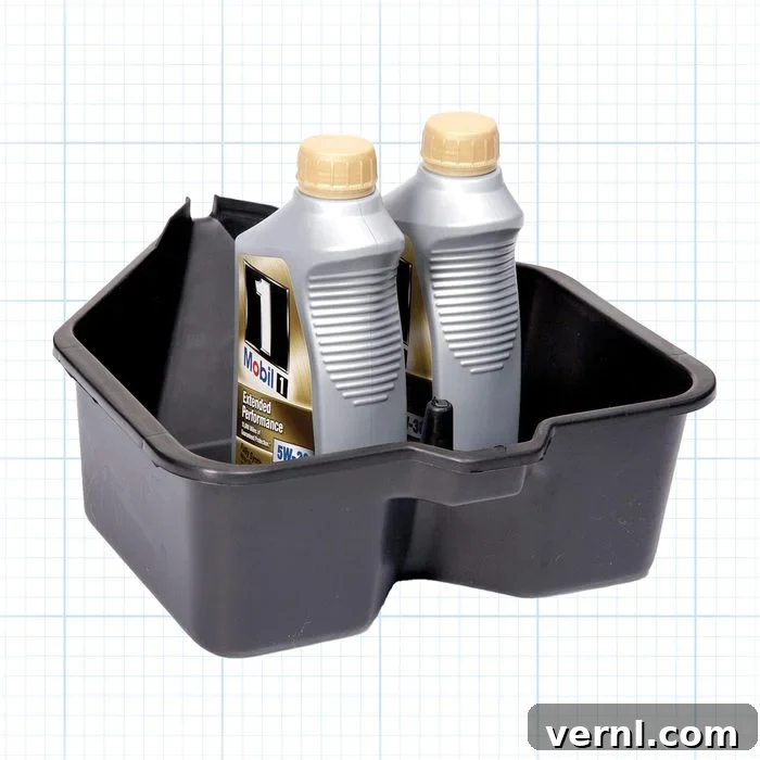 Bulletproof Your Backup: The Ultimate Generator Maintenance Handbook 2 A black, rectangular oil drain pan with a spout on one side, containing two bottles of motor oil with beige caps and silver labels, placed on a grid-patterned background.