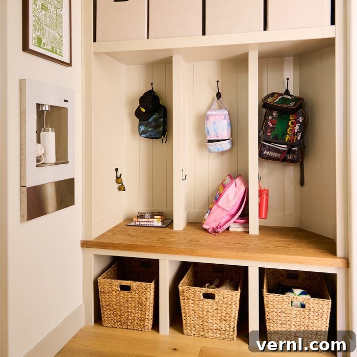 The Craft of Influence: Kyle Ortiz's DIY Legacy Home 3 A neatly organized mudroom features three cubbies with hooks. Each cubby holds a backpack and some accessories. Below, there are three woven baskets for additional storage. The left wall has a mounted water bottle filler and a framed map above it.
