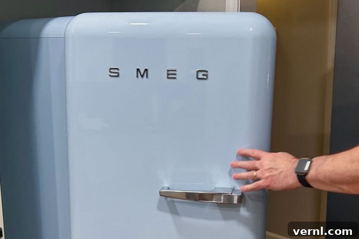 Smeg Fridge Review: Is the Style Just Skin Deep? 6 Hand can be seen opening the Smeg Fab 28 Fridge