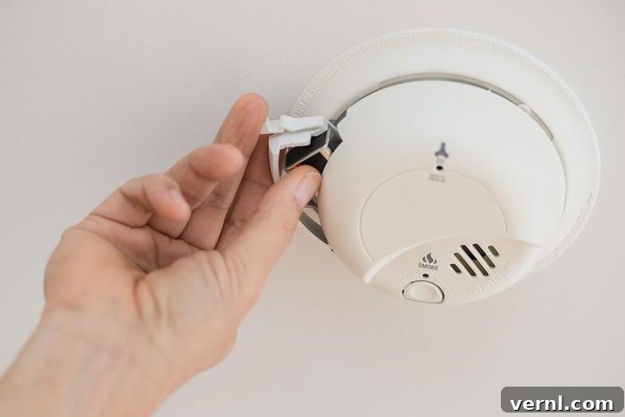 False Fire Alarms Explained 4 Common Triggers 2 A person changing batteries of the fire alarm