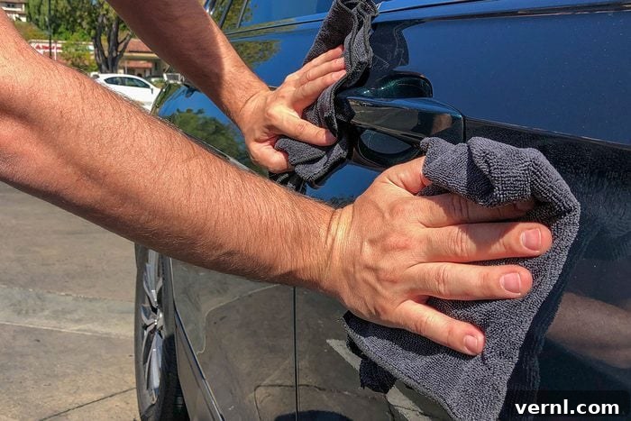 Mastering Stubborn Bird Poop Removal 2 A man cleaning car with microfiber cloth, focusing on removing bird droppings