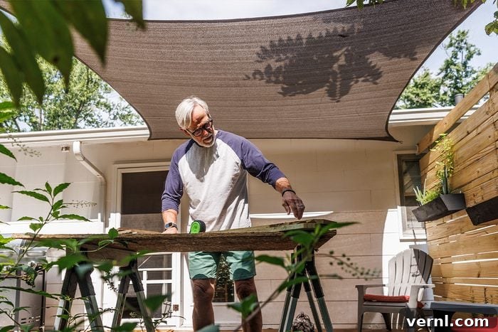 Don't Sweat Your Summer DIY Essential Cooling Tools 4 Man working in the shade provided by an umbrella while doing home maintenance to stay cool